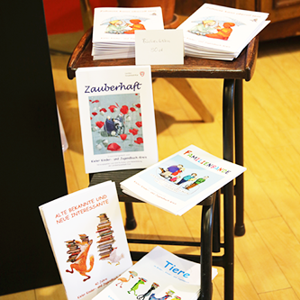 verschiedene Bücherlisten liegen auf einem Stuhl